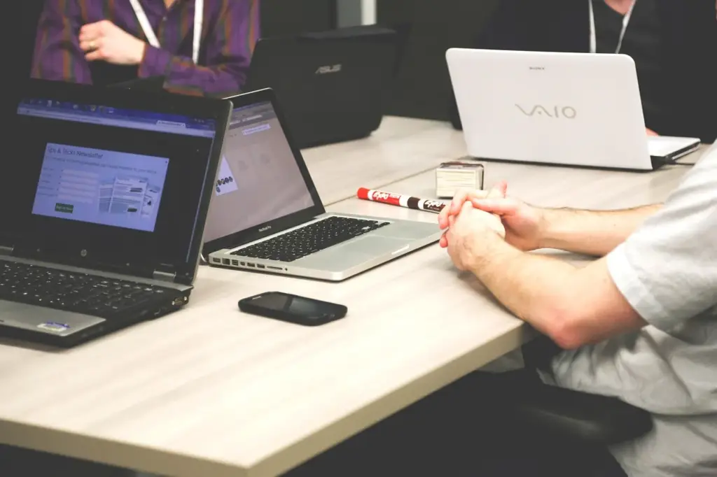 Two coworkers looking at a content audit report on a desk