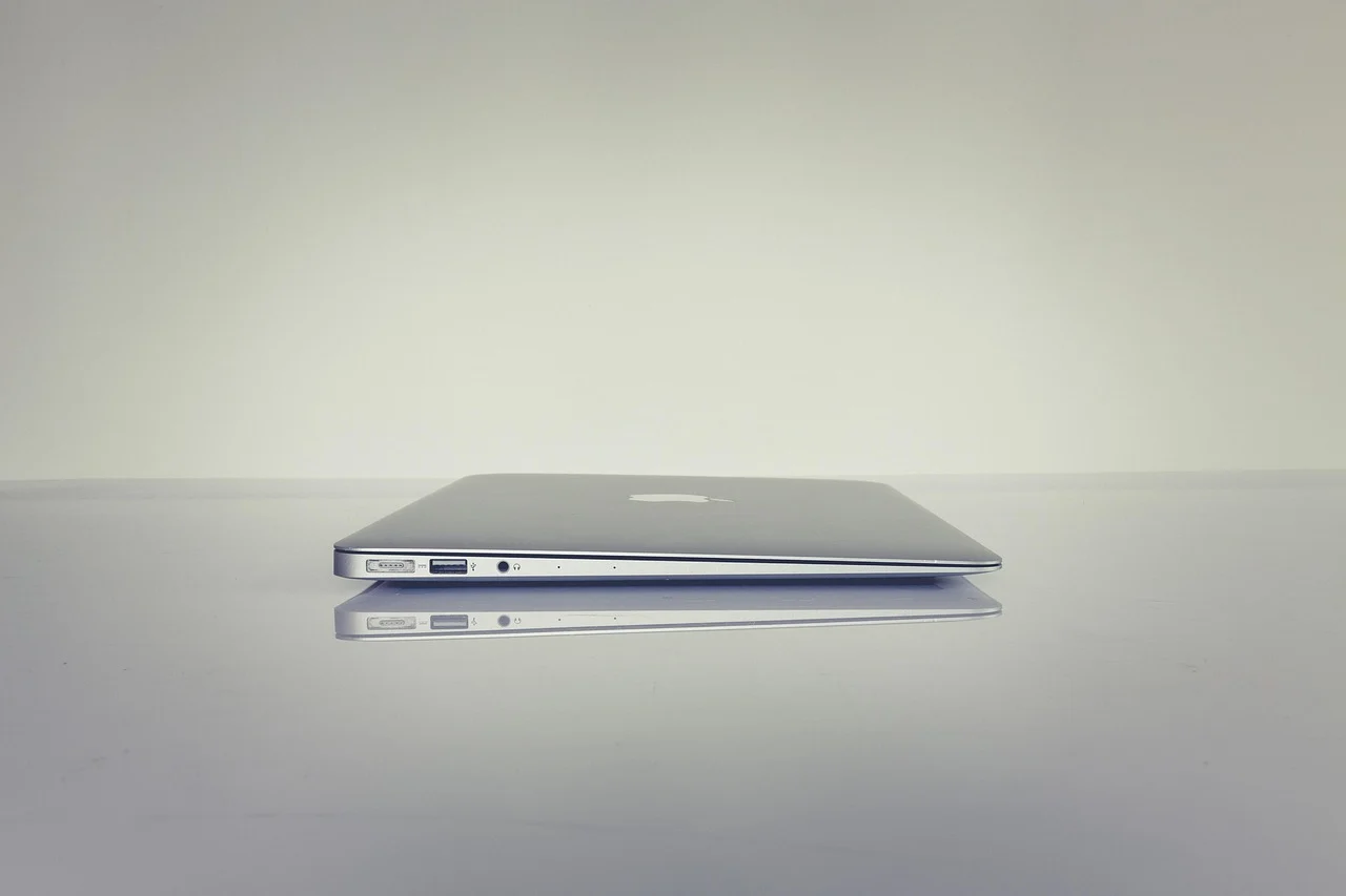 A notebook with a handwritten SEO checklist next to a laptop on a desk